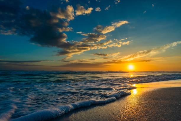 istock a beach with a bunch of waves at sunset and clouds 1498385857