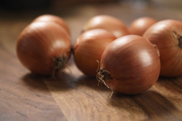 istock brown onions on old wood table 1498388624