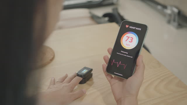 Southeast asian Woman use mobile application to monitor blood pressure
