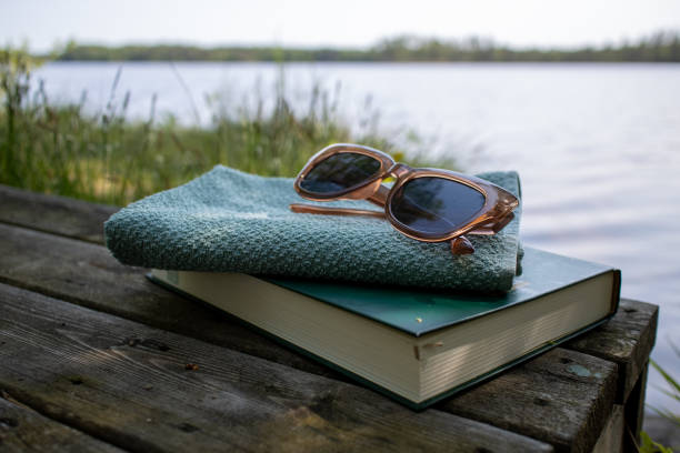 Lake view and book with towel and sunglasses midsummer in Finland