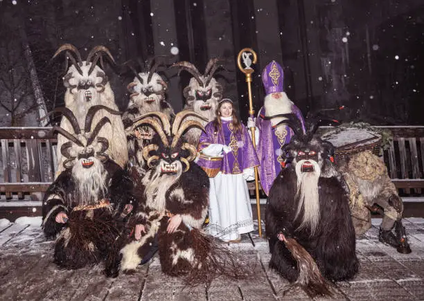 Group photo of St. Nicholas and the Krampus in the Christmas procession on the wooden bridge, Austria, Gastein. High quality photo