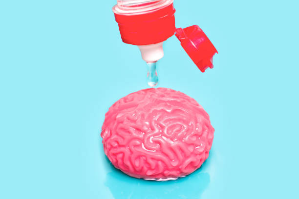 istock Water Droplet Suspended Above Human Brain Model on Blue 1498394581