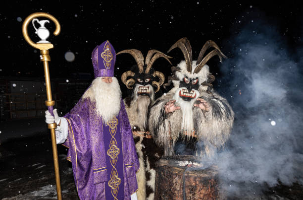 héroes de navidad, san nicolás y krampus tomando el sol en un tocón humeante, austria, gastein - mythology snow winter austria fotografías e imágenes de stock