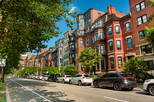 Victorian style houses and apartments along the cobblestone sidewalks of Commonwealth Avenue in the Back Bay neighbourhood district in Boston Massachusetts USA
