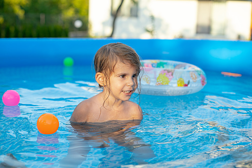 Portrait of cute girl playing in the pool