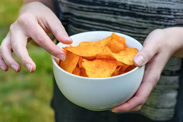 Woman holding a bowl of salted pepper chipscloseup