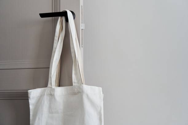 istock White eco friendly bag hanging on the door handle. Canvas tote bag 1498404261