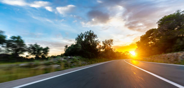 istock Empty long road on a sunny summer day at bright sunset 1498406483