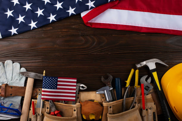 istock Tools hardhat toolbelt and us flag on wooden background labor day banner mockup 1498407020