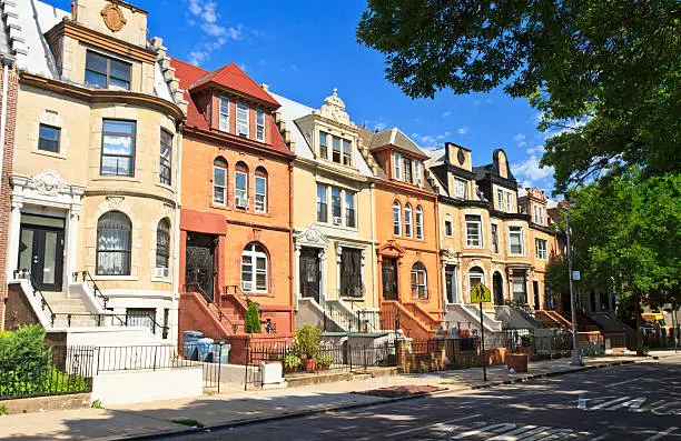 A row of unique townhouse apartment buildings with stoops on New York Ave. in the Crown Heights neighborhood of Brooklyn, NY.