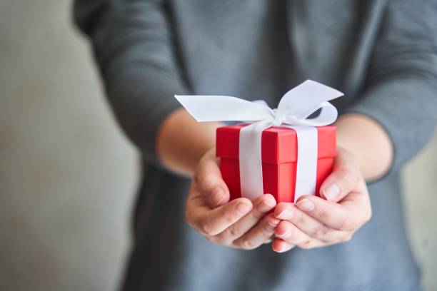 istock Woman holding small red present box in hands. 1498409611