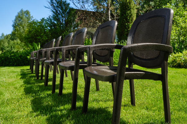 istock Wet dark brown chairs in green garden. 1498414293