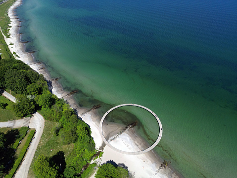 Panoramic aerial view of the seaside of Aahus and the round shaped Infinite Bridge in the foreground on a sunny day in Aarhus, Denmark