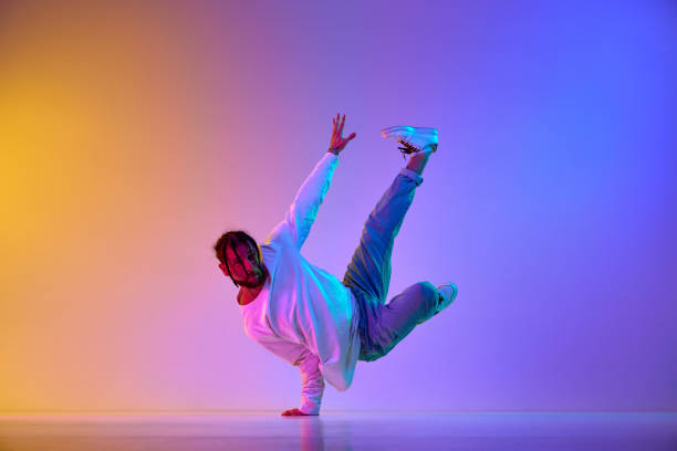 istock Dance show. Young guy dancing contemp, breakdance and hip-hop against gradient multicolored studio background in neon light 1498420722