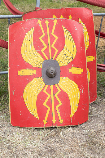 close up in vertical view of two vibrant red Scutum Augusta, shields of legionary soldiers from the ancient Roman Empire, evoking strength and authority