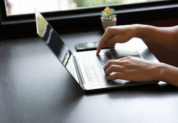 istock focused businessman sat at the elegant wooden table, his skilled hand swiftly tapping away on the sleek laptop keyboard, engrossed in his work. determined expression mirrored his dedication. close up. 1498423607