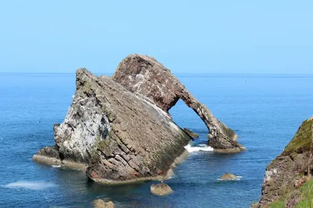 Photo of Bow Fiddle Rock is a natural sea arch near Portknockie on the north-eastern coast of Scotland. It is so called because it resembles the tip of a fiddle bow