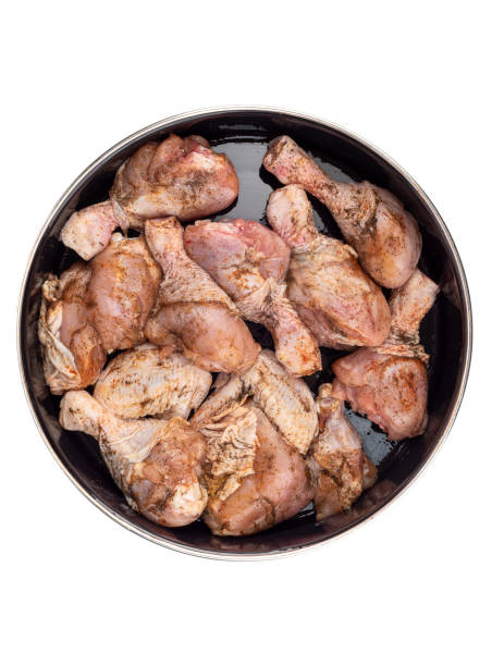 istock Top view of chicken drumsticks in a pan ready for baking, sprinkled with pepper, salt. 1498425607