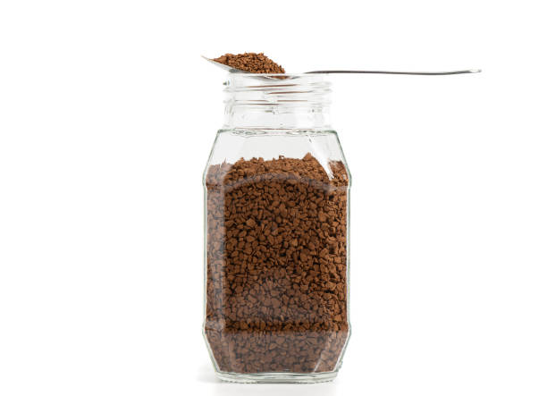 istock Transparent glass jar with instant granulated coffee on a white background. 1498425860