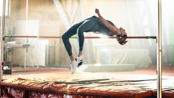 istock Sportswoman high jumping through pole 1498428853