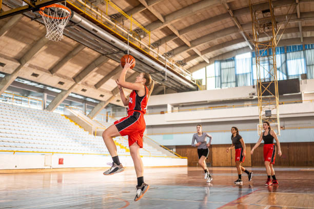 istock Basketball female team throwing ball into hoop 1498429140