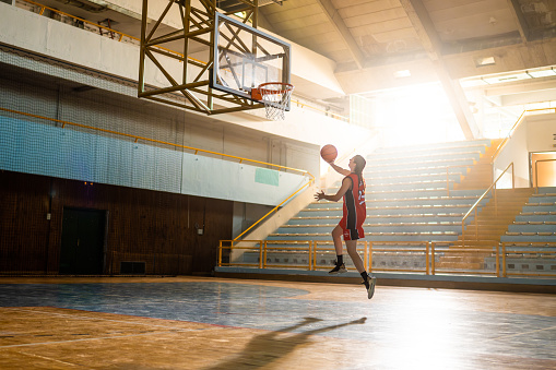 A portrait of a kid girl playing with a basketball in park