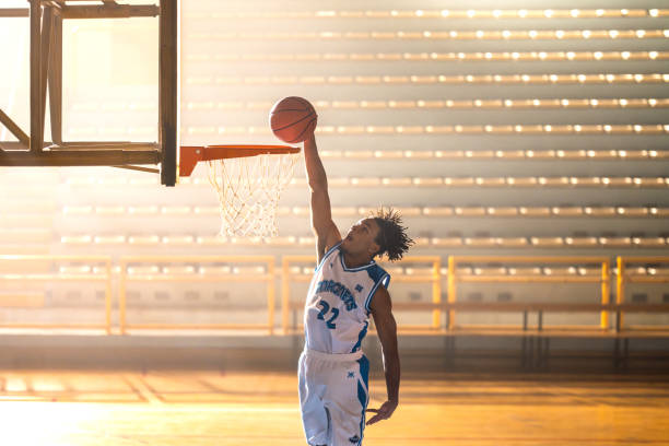 istock Basketball player throwing ball through hoop 1498429186