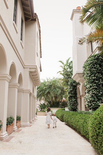 istock Lifestyle Candid Moment of a Brother & Sister Walking Together Holding Hands Wearing Sage Green & White Spring Wear in Palm Beach, Florida in May of 2023, Cuban-American 4-Year-Old Toddler Girl & 1-Year-Old Baby Boy Both with Light Brown Hair 1498432200