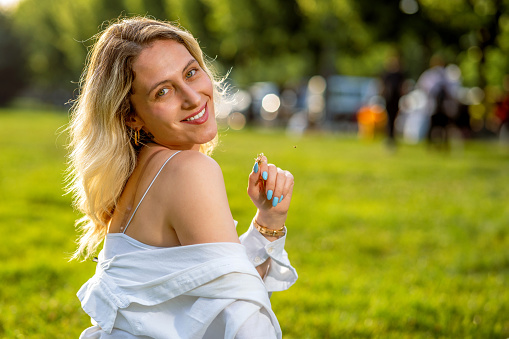Beautiful blonde woman sitting on the grass