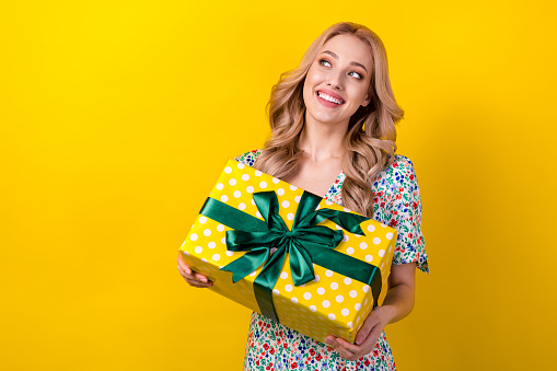 Portrait of cheerful gorgeous lady wear stylish clothes rejoice festive event look empty space isolated on yellow color background.