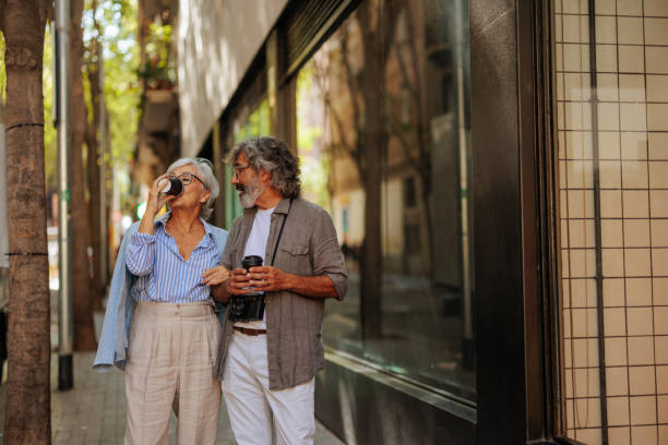 istock Senior couple drink coffee on street. 1498435569