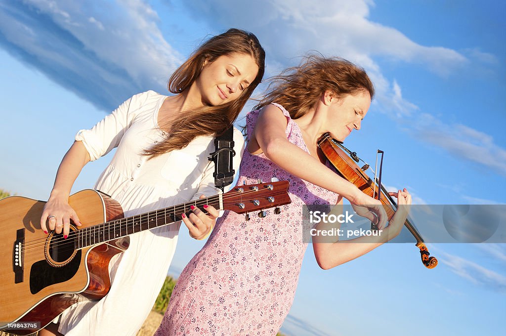 Deux jeunes femmes jouant de la guitare et violon en plein air - Photo de Confiture libre de droits