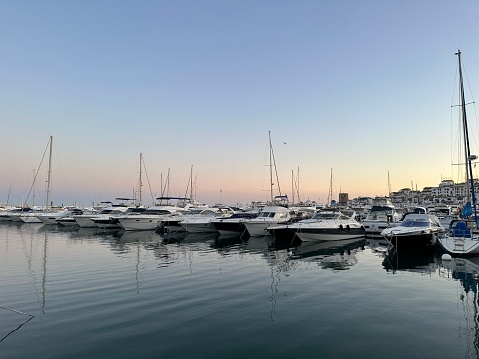 Boats moored in Puerto Banus marina in Spain at dusk on a still day