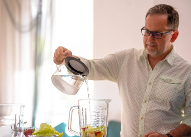 istock Man pours water for smoothies 1498443215
