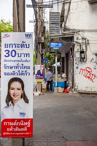 Bangkok, Thailand - March 24th 2023: Advertisement posters in front of a street vendors shop in the center of the capital of Thailand