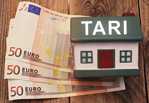 casa con billetes en euros y el texto Tari concepto de iItalian Tax photo