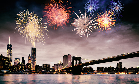 Fireworks over Brooklyn Bridge and World Trade Center, Lower Manhattan NY, USA. Toned Image.