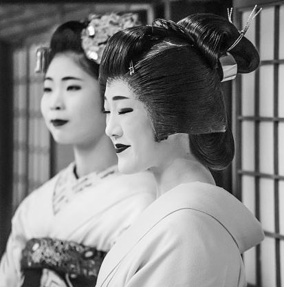 Kyoto, Japan - April 05, 2023 - A Geisha and a Maiko (young trainee geisha) demonstrating slow-moving traditional dance in Kyoto, one of the last strongholds of geisha culture in Japan. Maiko are trained for around five years by their okiya mother and a more senior geiko.