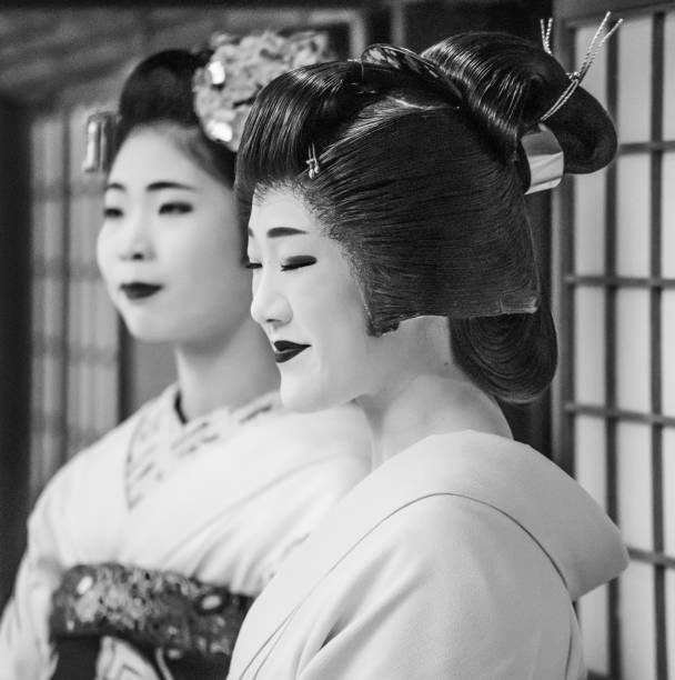 Geisha and Maiko entertain tourists with a traditional dancing performance in Kyoto, Japan stock photo