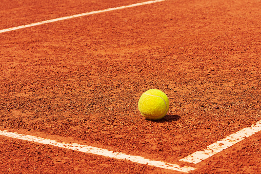 Tennis court. Tennis ball on a clay court near the line