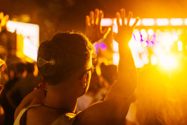 istock Young man holding hands up at concert 1498454893