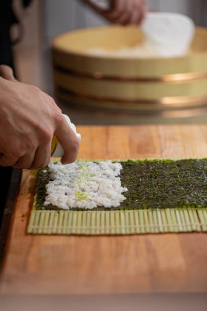 istock Chef cooking sushi rolls with rice and nori 1498455716