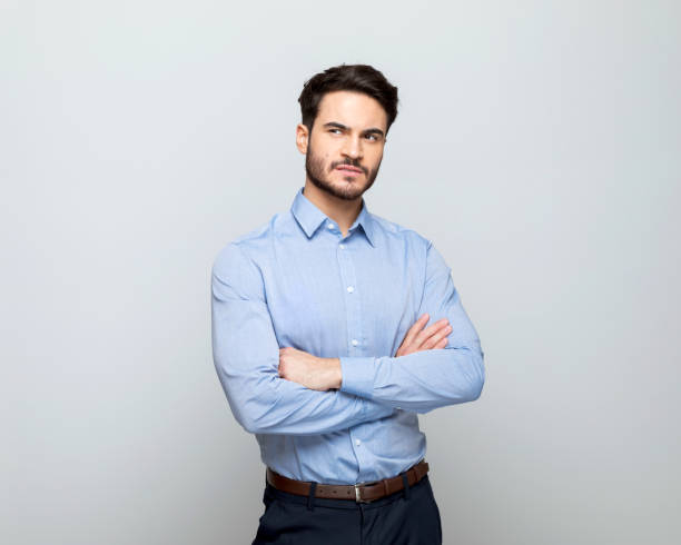 istock Thoughful businessman standing with arms crossed 1498456615