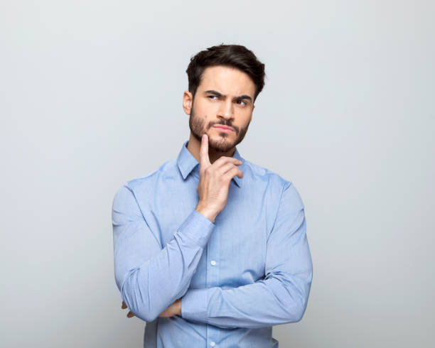 istock Thoughful businessman standing with hand on chin 1498457136