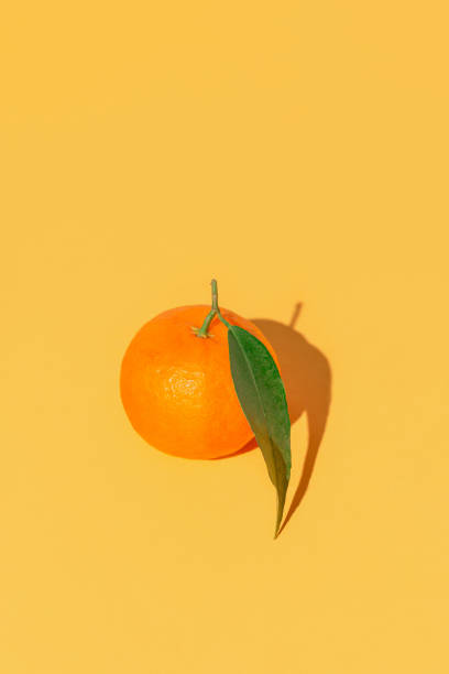 istock Minimal style composition made of fresh orange mandarin with green leaf on bright background. Summer refreshment and vitamin concept. 1498457727