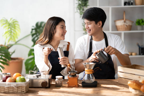 istock Young smiling couple in love spending a weekend morning together while making coffee at the kitchen, having breakfast together. 1498457867