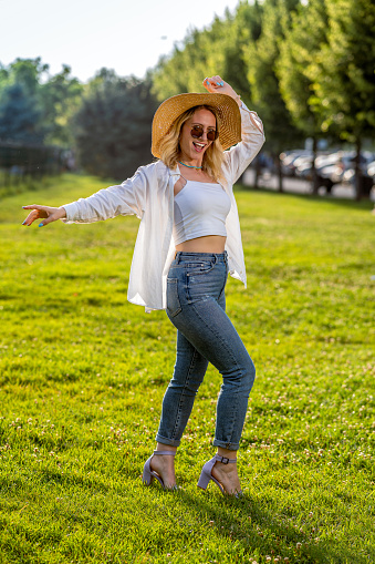 Woman in nature with straw hat and sunglasses