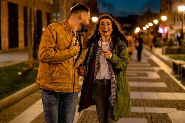 Serene Night Couple takes a peaceful walk together on a quiet night street date night romance stock pictures, royalty-free photos & images