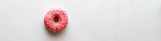 istock Banner Flat lay pink donut on color background. Dessert with icing 1498459332