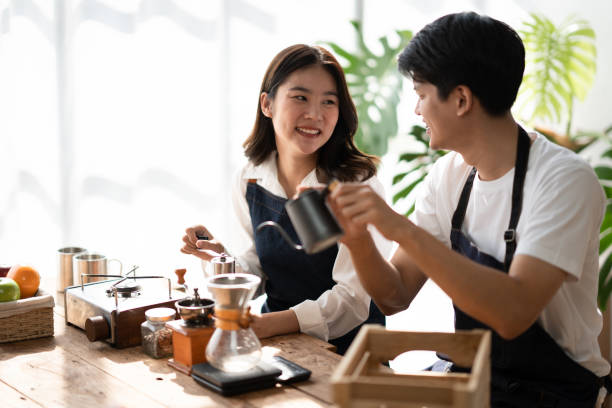 istock Young smiling couple in love spending a weekend morning together while making coffee at the kitchen, having breakfast together. 1498460498